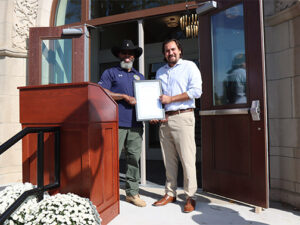 Jeremiah Jones, Board Chair, District 4 Commissioner and another hold a plaque